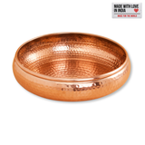Hand-hammered copper-finish urli bowl showing its empty interior against a white background.